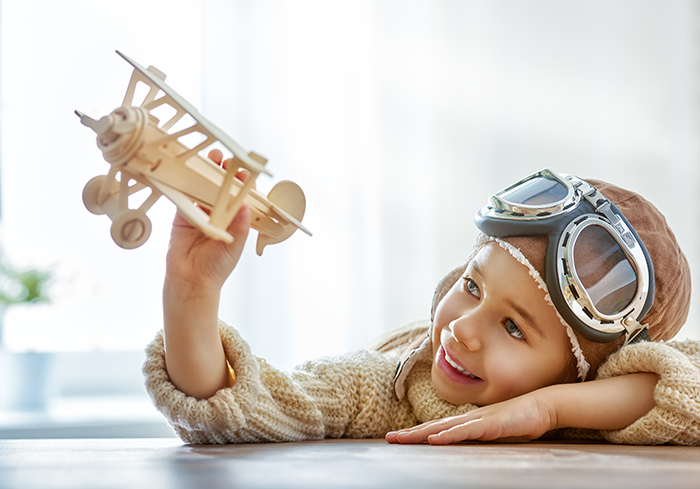 girl playing with toy airplane